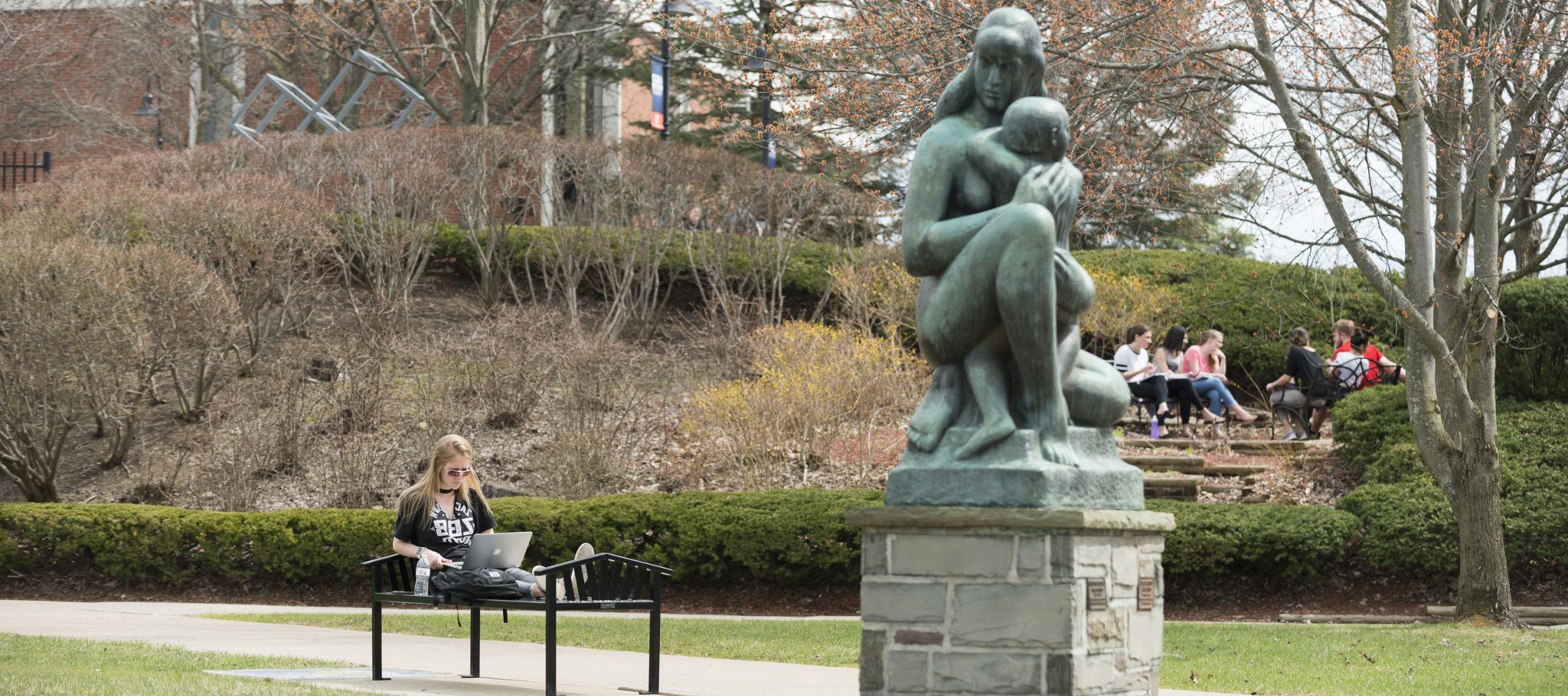 Campus Scenic Spring - Students work near statue